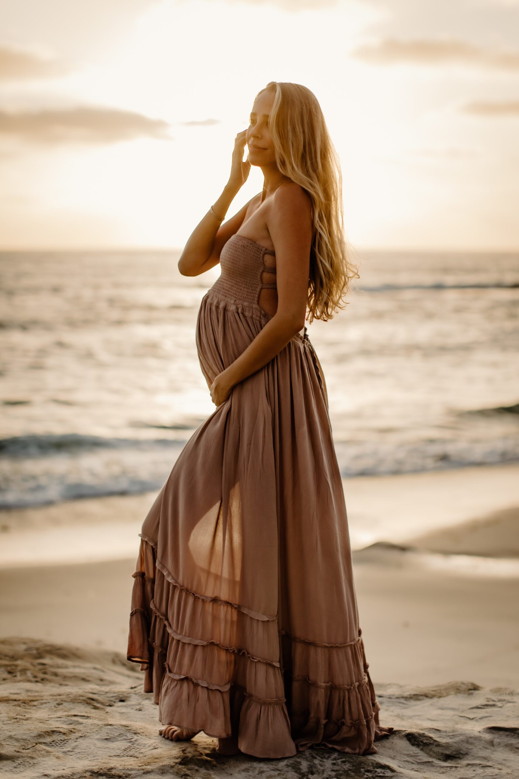 Pregnant woman posing on the beach in San Diego during her maternity session