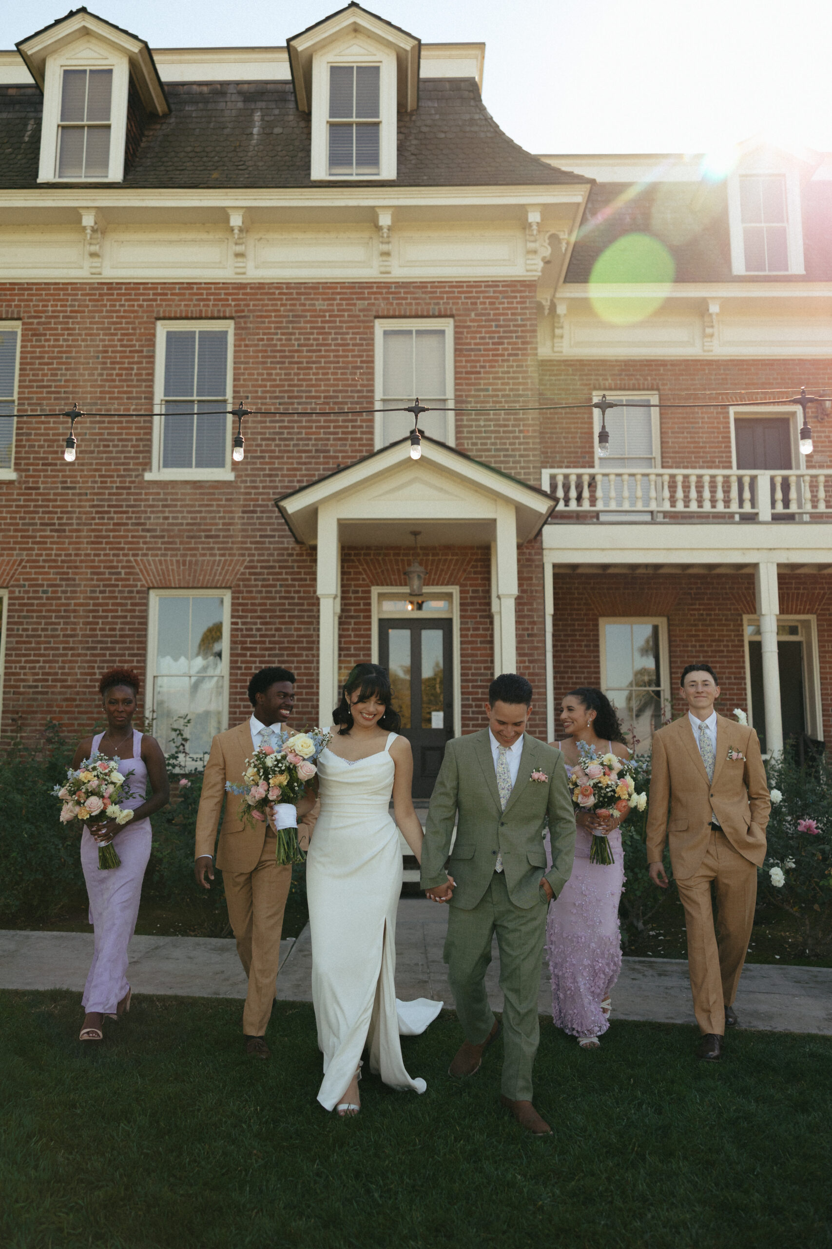 A wedding party walks in front of The Barton House wedding venue in Redlands, California